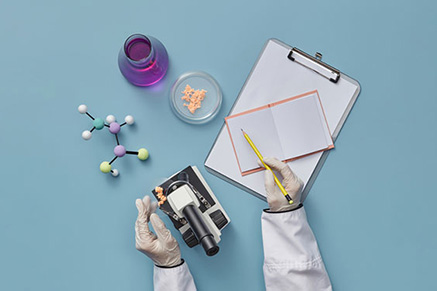 A flat lay photo of a scientist writing in a notebook